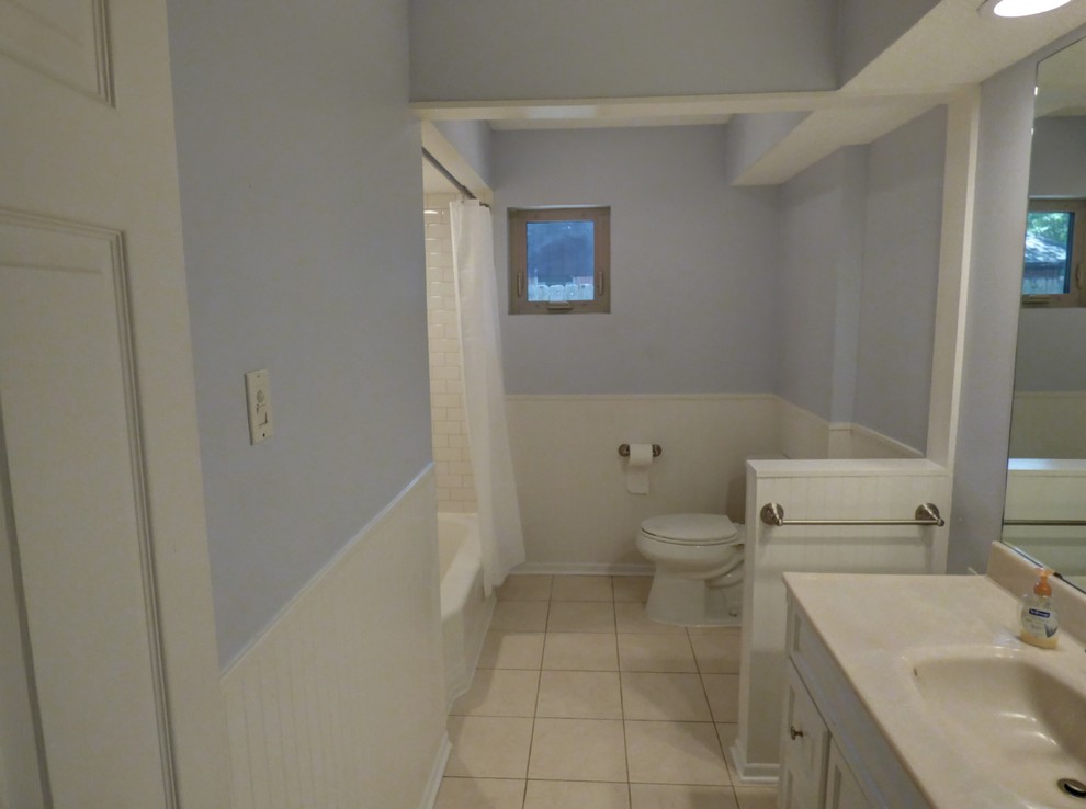 Idéer för ett mellanstort klassiskt beige badrum för barn, med luckor med upphöjd panel, vita skåp, ett badkar i en alkov, en dusch i en alkov, en toalettstol med separat cisternkåpa, vit kakel, tunnelbanekakel, blå väggar, klinkergolv i keramik, ett integrerad handfat, marmorbänkskiva, beiget golv och dusch med duschdraperi