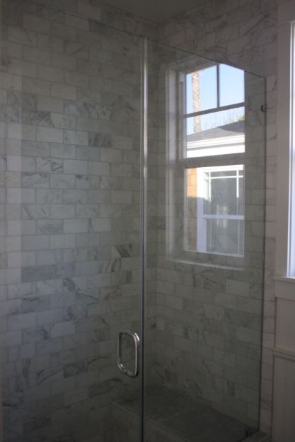 Example of a transitional gray tile, white tile and stone tile alcove shower design in Los Angeles