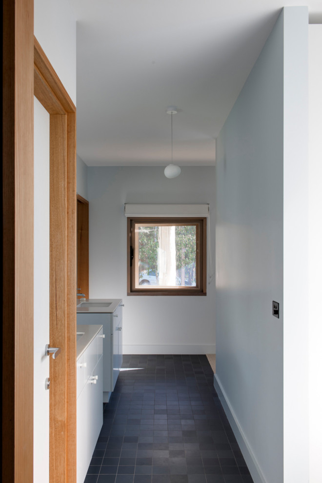 На фото: ванная комната среднего размера в стиле модернизм с плоскими фасадами, синими фасадами, синими стенами, полом из керамогранита, врезной раковиной, столешницей из искусственного камня, синим полом и белой столешницей