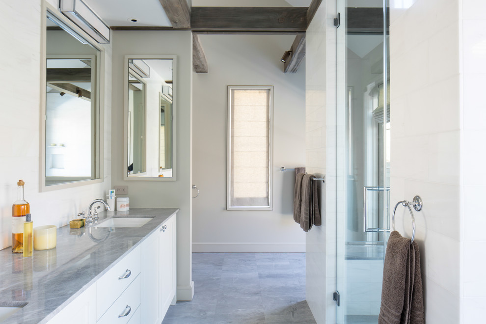 Ejemplo de cuarto de baño moderno con armarios con paneles lisos, puertas de armario blancas y encimera de mármol