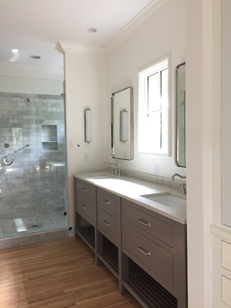 Photo of a large modern ensuite bathroom in Other with flat-panel cabinets, grey cabinets, a freestanding bath, grey tiles, marble tiles, white walls, ceramic flooring, a console sink, engineered stone worktops and beige floors.