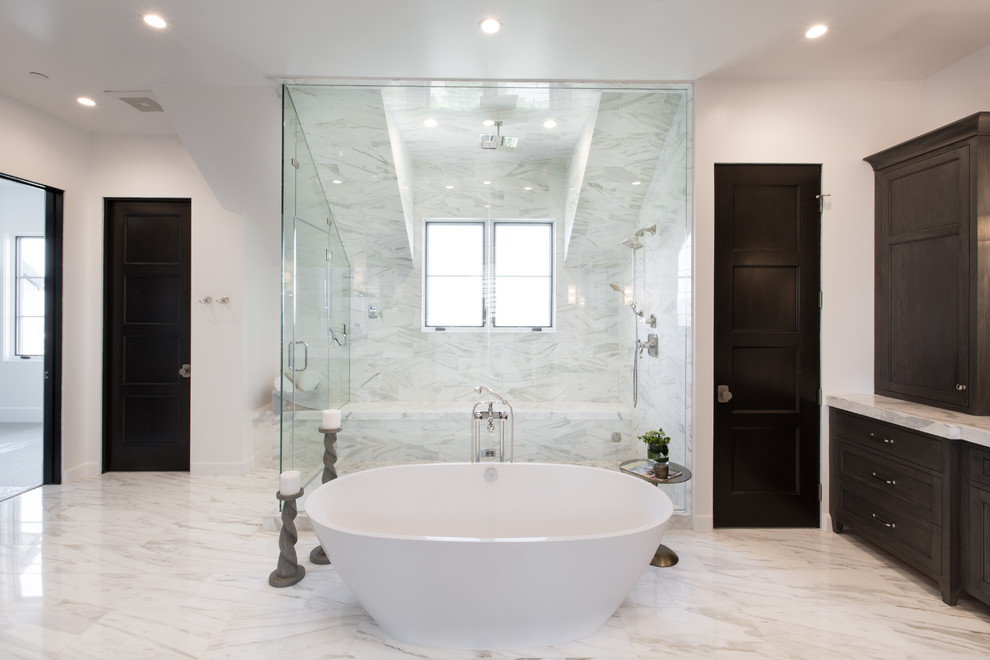Источник вдохновения для домашнего уюта: огромная главная ванная комната в стиле неоклассика (современная классика) с фасадами с утопленной филенкой, темными деревянными фасадами, отдельно стоящей ванной, открытым душем, унитазом-моноблоком, белой плиткой, каменной плиткой, белыми стенами, мраморным полом, врезной раковиной и столешницей из гранита