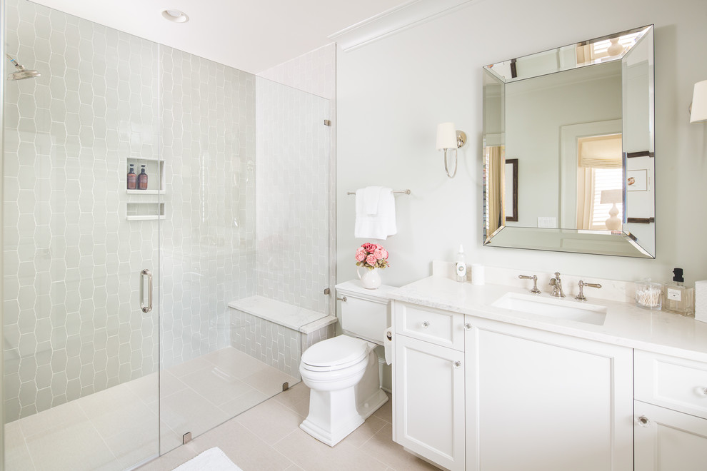 Inspiration for a traditional family bathroom in Atlanta with beaded cabinets, white cabinets, a built-in shower, a two-piece toilet, white tiles, ceramic tiles, white walls, ceramic flooring, a submerged sink, marble worktops, beige floors, a hinged door and white worktops.