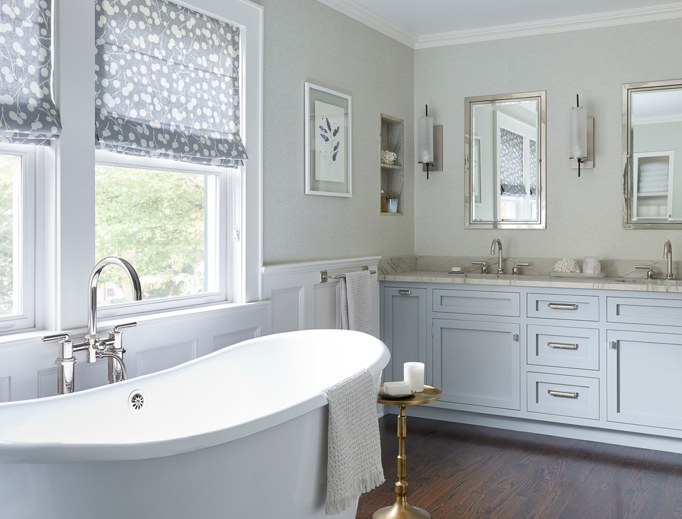 Idee per una stanza da bagno tradizionale con ante in stile shaker, ante grigie, vasca freestanding, pareti grigie, parquet scuro, lavabo sottopiano, pavimento marrone e top bianco