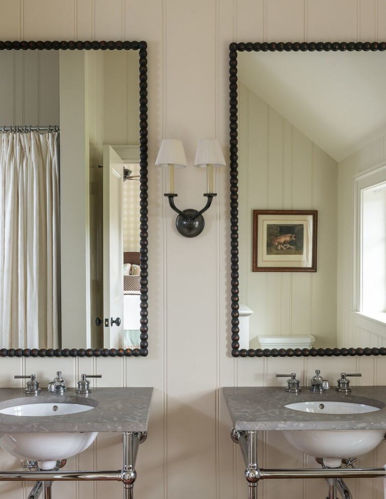 Modelo de cuarto de baño principal de estilo de casa de campo con paredes beige, lavabo tipo consola, encimeras grises y espejo con luz