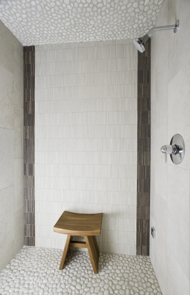 Cette image montre une salle de bain design avec un carrelage blanc, mosaïque et un sol en galet.