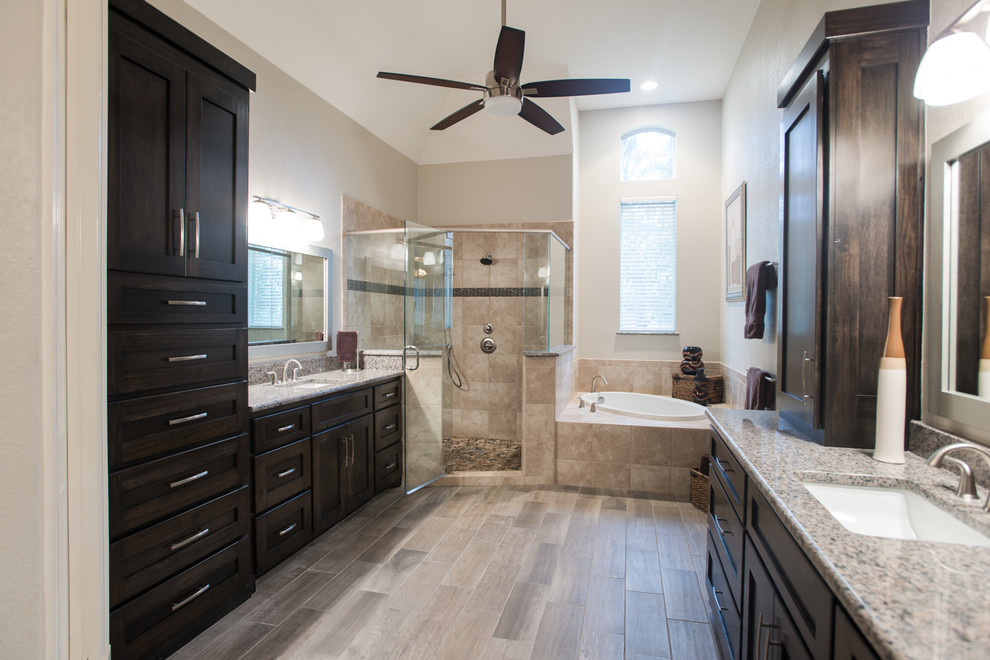 Inspiration for a large transitional master beige tile and porcelain tile porcelain tile and gray floor bathroom remodel in Dallas with granite countertops, a one-piece toilet, beige walls, dark wood cabinets, shaker cabinets, an undermount sink and a hinged shower door