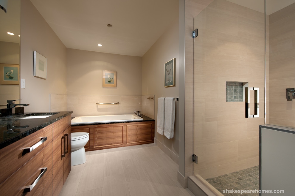 На фото: большая главная ванная комната в современном стиле с плоскими фасадами, фасадами цвета дерева среднего тона, столешницей из гранита, накладной ванной и бежевой плиткой с