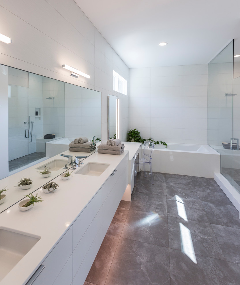 Idee per una stanza da bagno minimalista con ante lisce, ante bianche, piastrelle bianche, pareti bianche, pavimento grigio, porta doccia a battente, top bianco, vasca ad alcova e lavabo sottopiano