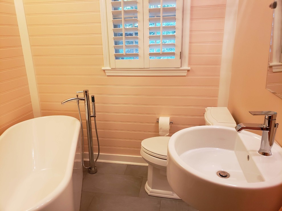 Ispirazione per una stanza da bagno con doccia tradizionale di medie dimensioni con vasca freestanding, WC a due pezzi, pareti rosa, pavimento in cemento, lavabo a colonna e pavimento grigio