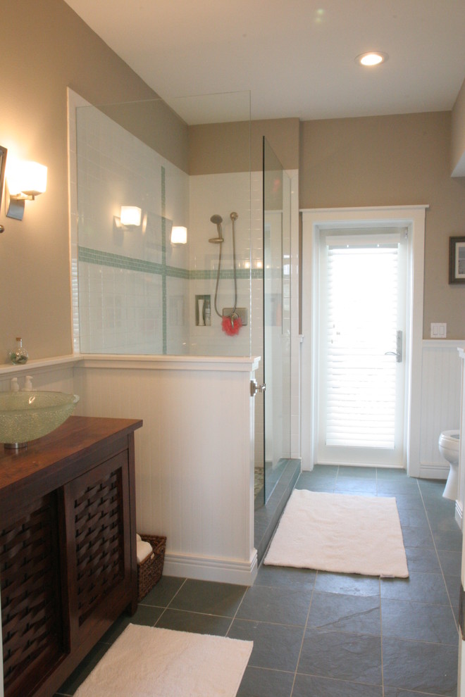 Bathroom - mid-sized coastal 3/4 gray tile and porcelain tile porcelain tile bathroom idea in Tampa with a vessel sink, furniture-like cabinets, medium tone wood cabinets, wood countertops, a one-piece toilet and beige walls