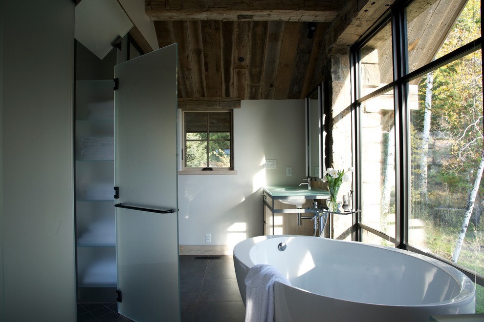 Immagine di una stanza da bagno padronale minimalista di medie dimensioni con ante di vetro, vasca freestanding, pareti bianche, top in vetro, doccia alcova, pavimento in ardesia e lavabo sottopiano
