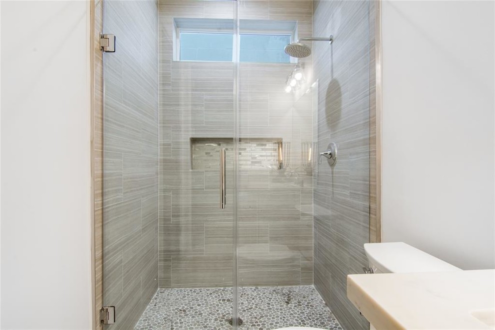 Design ideas for a large contemporary shower room bathroom in Houston with shaker cabinets, white cabinets, an alcove shower, a one-piece toilet, white tiles, porcelain tiles, white walls, porcelain flooring, a submerged sink, engineered stone worktops, grey floors, a hinged door and white worktops.
