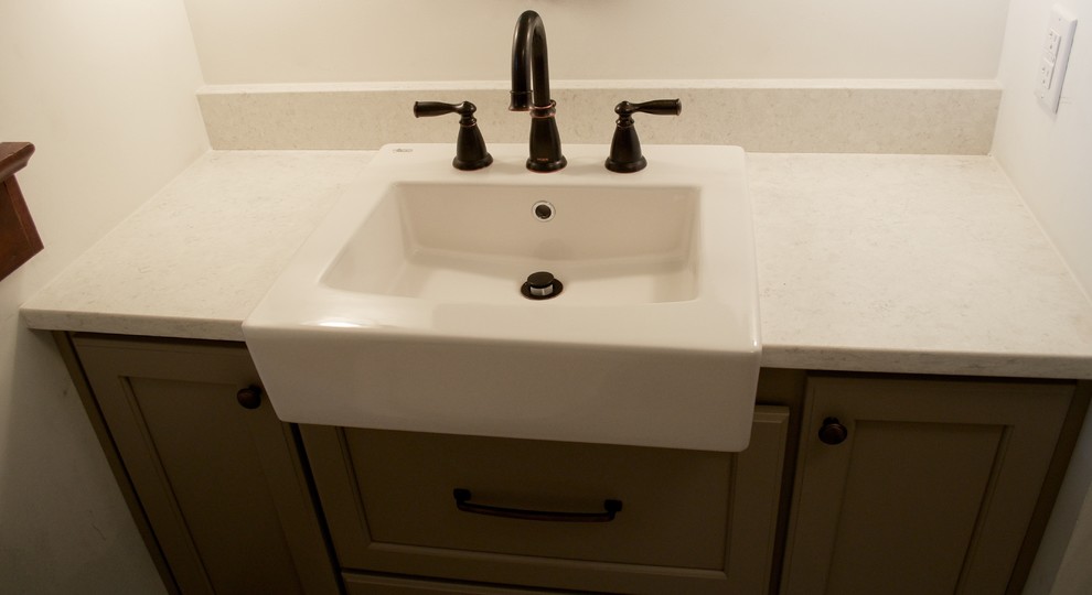 Retro inredning av ett litet badrum med dusch, med möbel-liknande, grå skåp, ett badkar i en alkov, en dusch/badkar-kombination, en toalettstol med separat cisternkåpa, grå kakel, porslinskakel, grå väggar, klinkergolv i porslin, ett fristående handfat och bänkskiva i kvarts