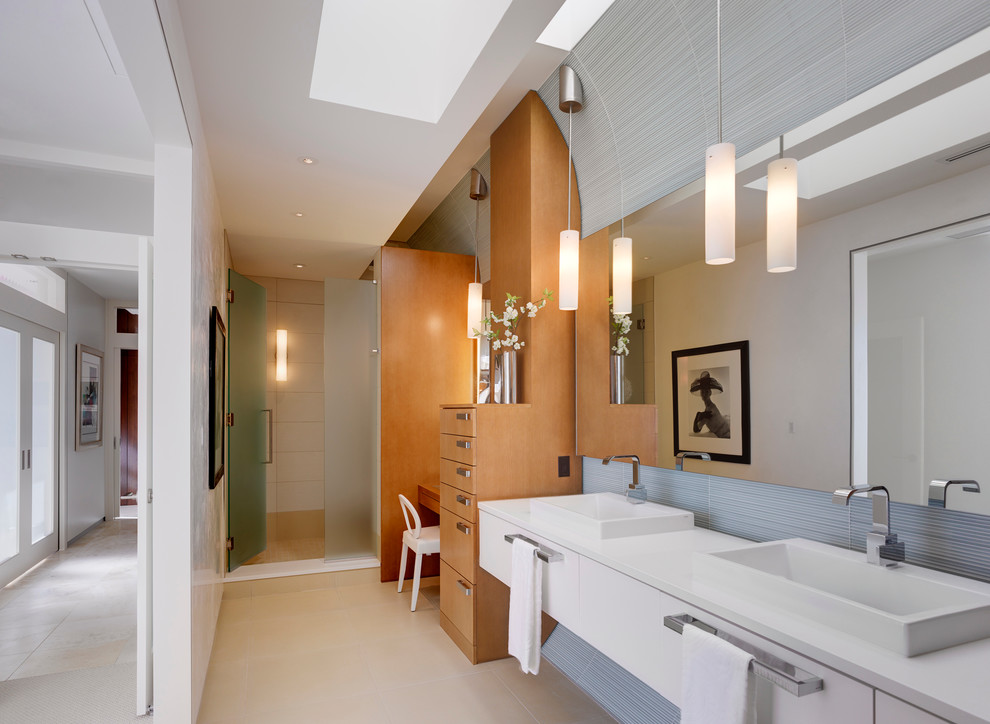 Inspiration for a medium sized contemporary bathroom in Indianapolis with a vessel sink, flat-panel cabinets, white cabinets, an alcove shower, grey tiles, engineered stone worktops, glass tiles, white walls and porcelain flooring.