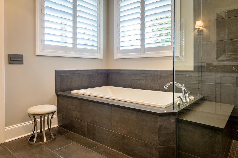 Example of a large trendy master brown tile and porcelain tile porcelain tile and brown floor bathroom design in Charleston with shaker cabinets, gray cabinets, a one-piece toilet, gray walls, an undermount sink, quartz countertops and a hinged shower door