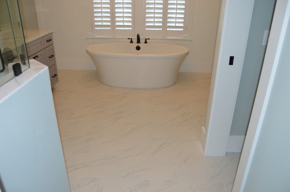На фото: главная ванная комната в стиле кантри с отдельно стоящей ванной, серыми стенами, полом из керамогранита и белым полом с