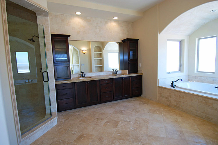 Medium sized mediterranean shower room bathroom in Los Angeles with raised-panel cabinets, dark wood cabinets, a built-in bath, an alcove shower, a one-piece toilet, multi-coloured tiles, travertine tiles, beige walls, travertine flooring, a submerged sink, soapstone worktops, multi-coloured floors, a hinged door and beige worktops.