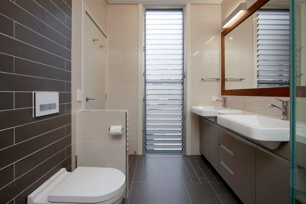 Inspiration för mycket stora moderna en-suite badrum, med släta luckor, grå skåp, en dusch i en alkov, en vägghängd toalettstol, beige kakel, porslinskakel, beige väggar, ett nedsänkt handfat, grått golv och dusch med gångjärnsdörr