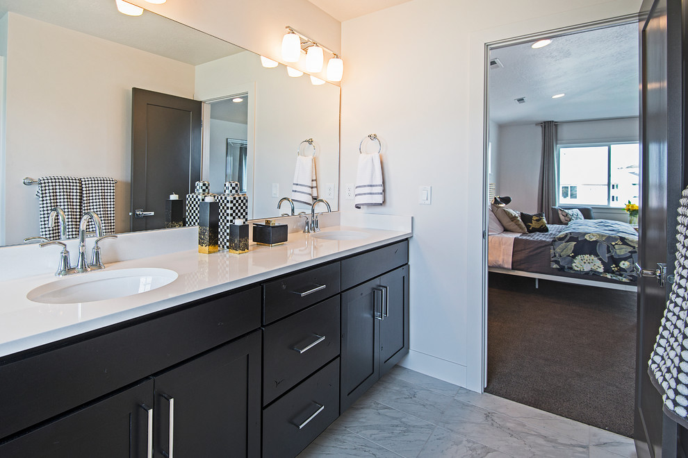 Bathroom - mid-sized contemporary master marble floor bathroom idea in Salt Lake City with a drop-in sink, recessed-panel cabinets, black cabinets, quartzite countertops, a one-piece toilet and white walls
