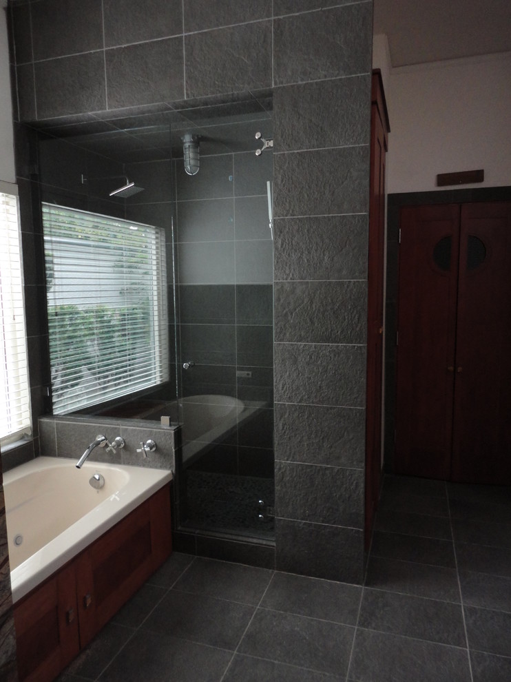 This is an example of a medium sized industrial ensuite bathroom in Dallas with a built-in bath, a corner shower, grey tiles, porcelain tiles, ceramic flooring, dark wood cabinets and white walls.