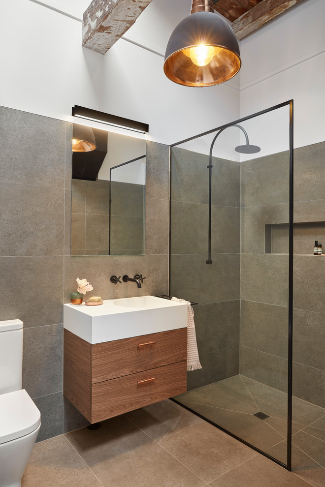 Design ideas for a small industrial shower room bathroom in Melbourne with flat-panel cabinets, dark wood cabinets, a walk-in shower, a one-piece toilet, grey tiles, porcelain tiles, porcelain flooring, an integrated sink, solid surface worktops, grey floors and an open shower.