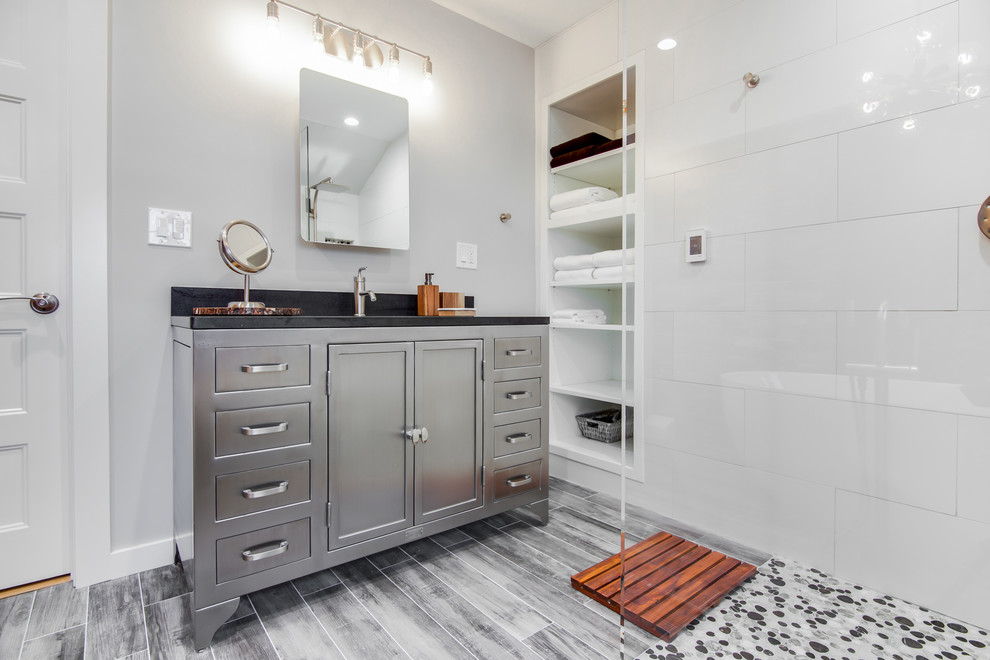 Exempel på ett mellanstort modernt en-suite badrum, med luckor med infälld panel, grå skåp, ett fristående badkar, en kantlös dusch, en toalettstol med hel cisternkåpa, svart och vit kakel, keramikplattor, grå väggar, klinkergolv i keramik, ett undermonterad handfat, granitbänkskiva och med dusch som är öppen