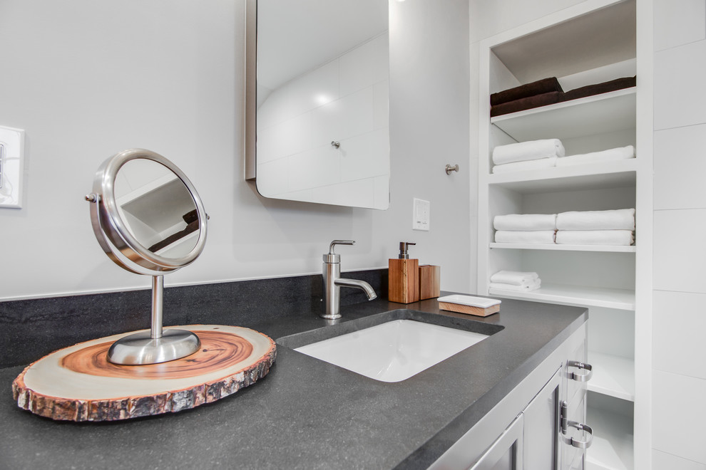 Mid-sized urban master black and white tile and ceramic tile ceramic tile bathroom photo in New York with recessed-panel cabinets, gray cabinets, a one-piece toilet, gray walls, an undermount sink and granite countertops