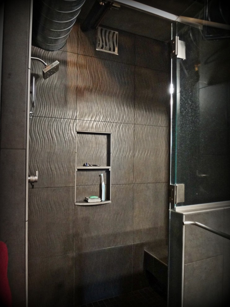 Exempel på ett mellanstort industriellt en-suite badrum, med ett integrerad handfat, ett platsbyggt badkar, en öppen dusch, en toalettstol med hel cisternkåpa, grå kakel, porslinskakel, grå väggar, betonggolv, släta luckor, svarta skåp och bänkskiva i rostfritt stål