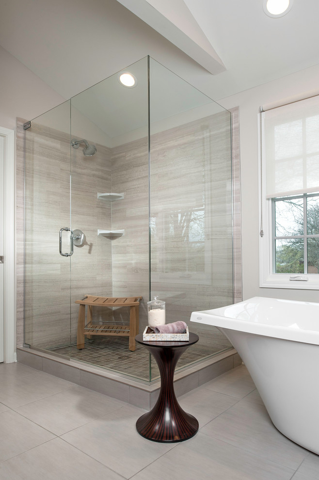 На фото: главная ванная комната в стиле неоклассика (современная классика) с отдельно стоящей ванной, угловым душем, серой плиткой, каменной плиткой, серыми стенами и полом из керамогранита