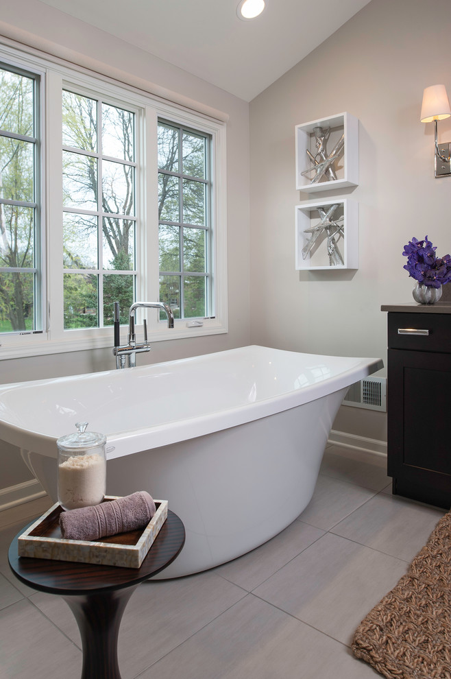 Bild på ett vintage en-suite badrum, med ett fristående badkar, en hörndusch, grå kakel, stenkakel, grå väggar och klinkergolv i porslin
