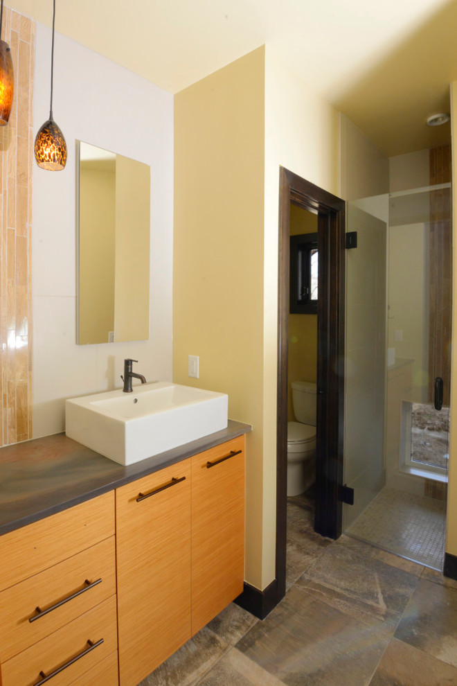 На фото: большая главная ванная комната в стиле кантри с плоскими фасадами, темными деревянными фасадами, желтыми стенами, полом из керамогранита, столешницей из бетона, настольной раковиной и разноцветным полом с