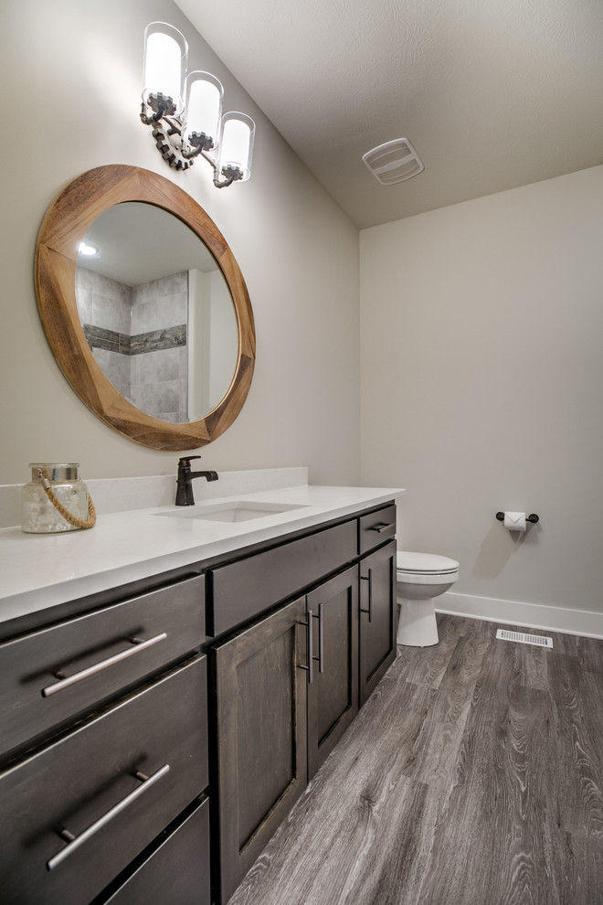Urban kids' porcelain tile bathroom photo in Omaha with shaker cabinets, dark wood cabinets, a two-piece toilet, an undermount sink and quartzite countertops