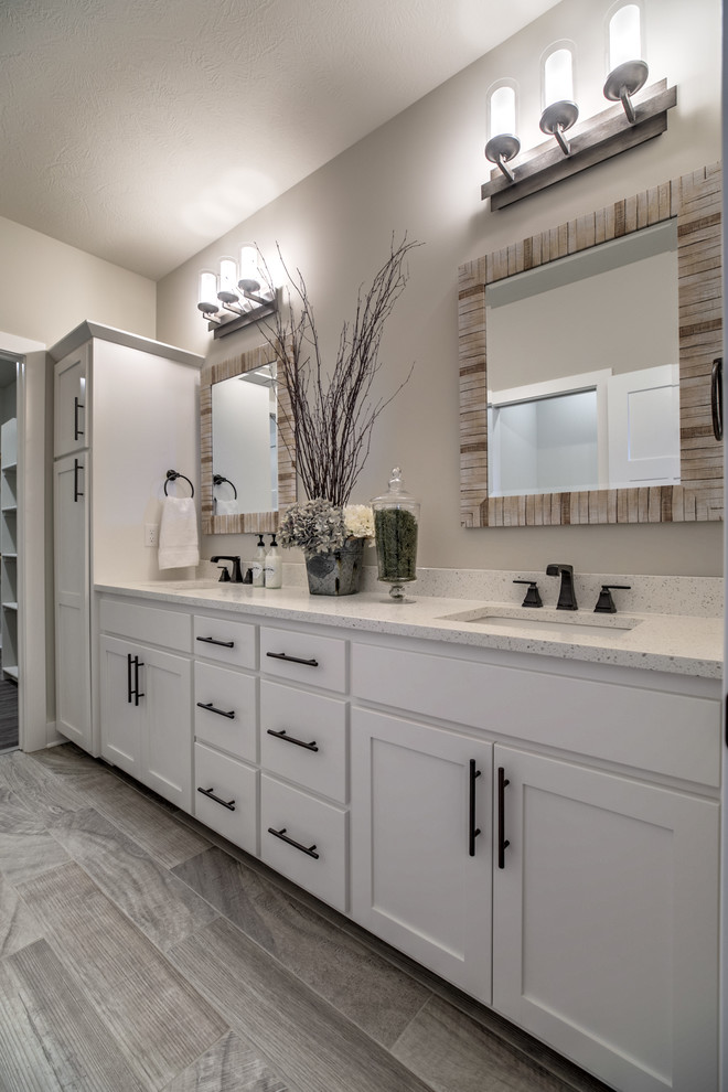 Inspiration for an industrial master porcelain tile open shower remodel in Omaha with shaker cabinets, white cabinets, a two-piece toilet, an undermount sink and quartzite countertops