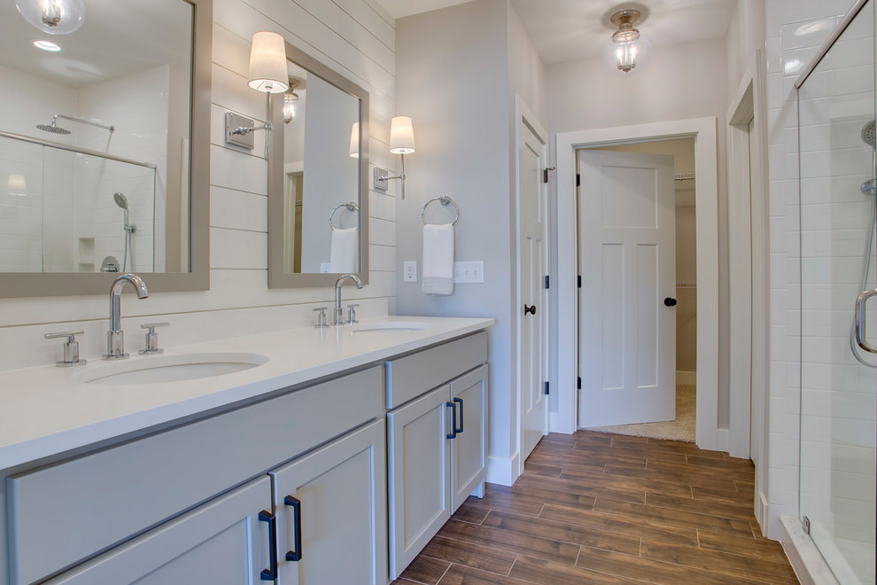 Mid-sized country master white tile and subway tile ceramic tile, brown floor, double-sink and shiplap wall bathroom photo in Chicago with shaker cabinets, medium tone wood cabinets, a two-piece toilet, gray walls, an undermount sink, quartz countertops, a hinged shower door, white countertops and a freestanding vanity