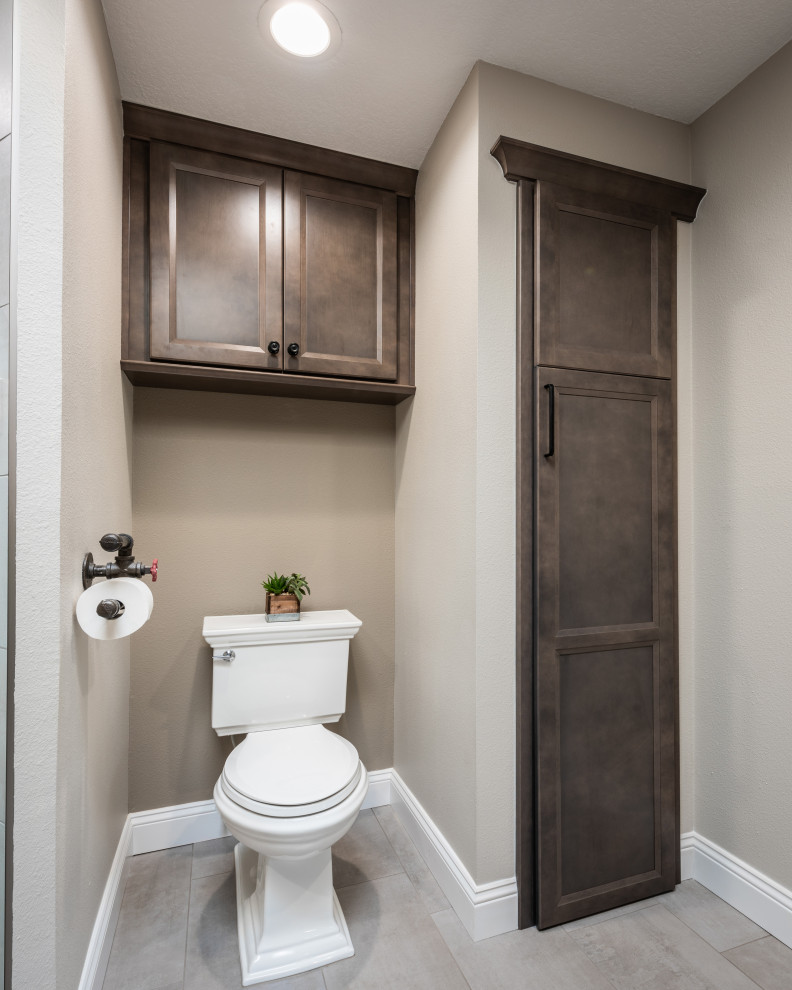 Foto på ett mellanstort industriellt grå toalett, med luckor med infälld panel, skåp i mellenmörkt trä, vit kakel, porslinskakel, grå väggar, klinkergolv i porslin, ett fristående handfat, bänkskiva i kvarts och grått golv