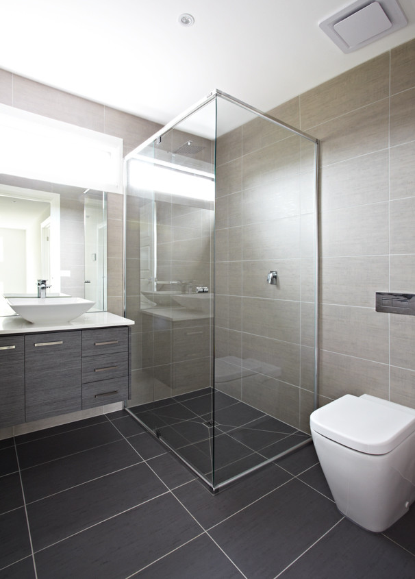 Inspiration pour une salle de bain principale design de taille moyenne avec une douche d'angle, WC suspendus, un carrelage beige, un mur gris, une vasque, un sol gris et une cabine de douche à porte battante.
