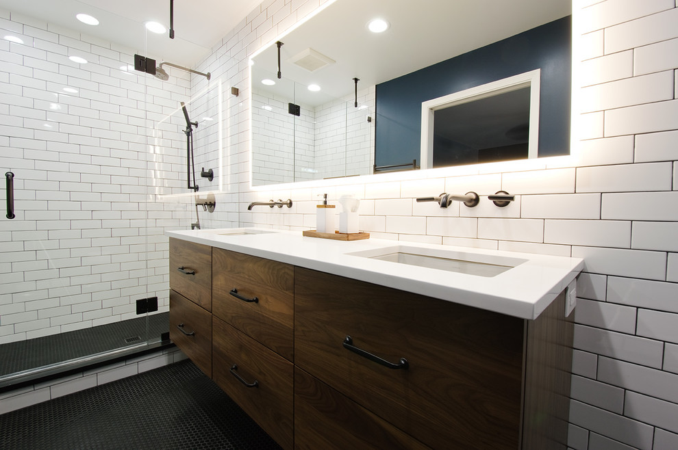 Пример оригинального дизайна: главная ванная комната среднего размера в стиле лофт с плоскими фасадами, коричневыми фасадами, душем в нише, унитазом-моноблоком, белой плиткой, керамической плиткой, синими стенами, полом из керамической плитки, врезной раковиной, столешницей из искусственного кварца и черным полом