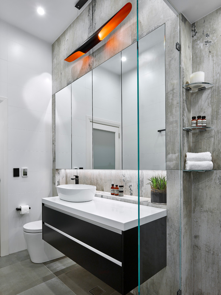 Идея дизайна: маленькая ванная комната в стиле модернизм с плоскими фасадами, черными фасадами, двойным душем, инсталляцией, серой плиткой, керамогранитной плиткой, полом из керамогранита, настольной раковиной и столешницей из искусственного камня для на участке и в саду