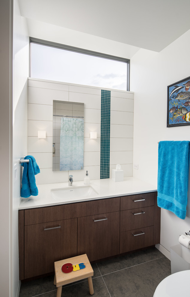 Cette photo montre une salle de bain moderne avec un placard à porte plane, un mur blanc et un lavabo encastré.