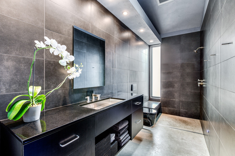 Esempio di una stanza da bagno industriale con ante lisce, ante nere, doccia aperta, piastrelle grigie, pareti grigie, lavabo sottopiano, pavimento grigio e doccia aperta