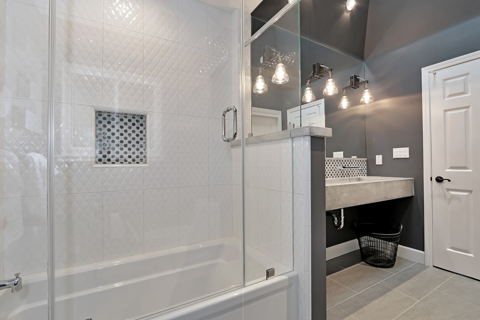 Idéer för mellanstora industriella grått badrum för barn, med ett integrerad handfat, bänkskiva i betong, ett badkar i en alkov, en dusch/badkar-kombination, en toalettstol med hel cisternkåpa, vit kakel, stenkakel, grå väggar, klinkergolv i keramik, grått golv och dusch med gångjärnsdörr
