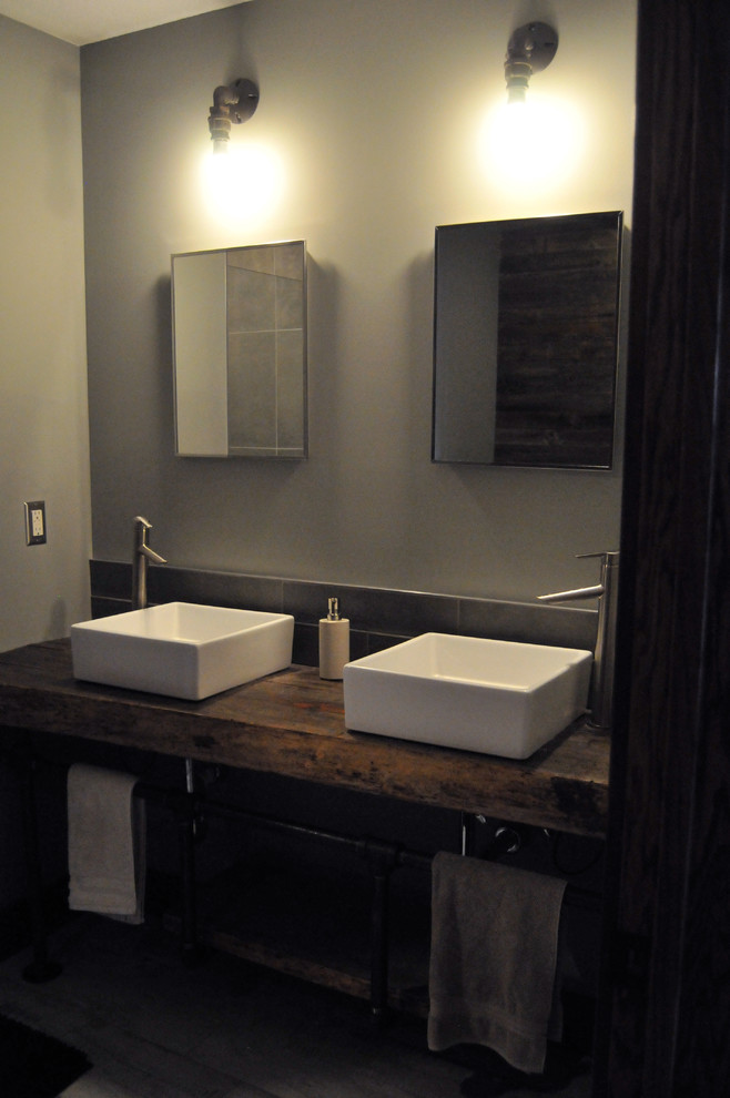 Esempio di una stanza da bagno industriale con vasca da incasso, piastrelle grigie, piastrelle in ceramica e pavimento con piastrelle in ceramica