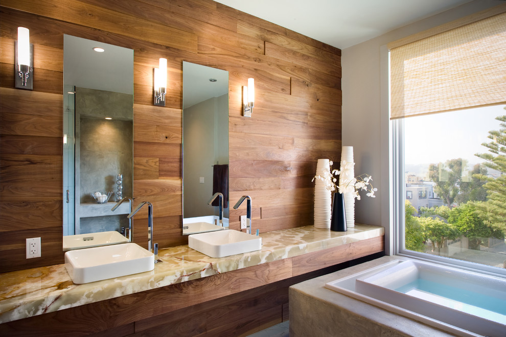 Cette photo montre une grande salle de bain principale tendance avec une vasque, un plan de toilette en onyx, une baignoire indépendante, un carrelage blanc, des carreaux de céramique, un mur blanc, un sol en carrelage de céramique et un plan de toilette beige.