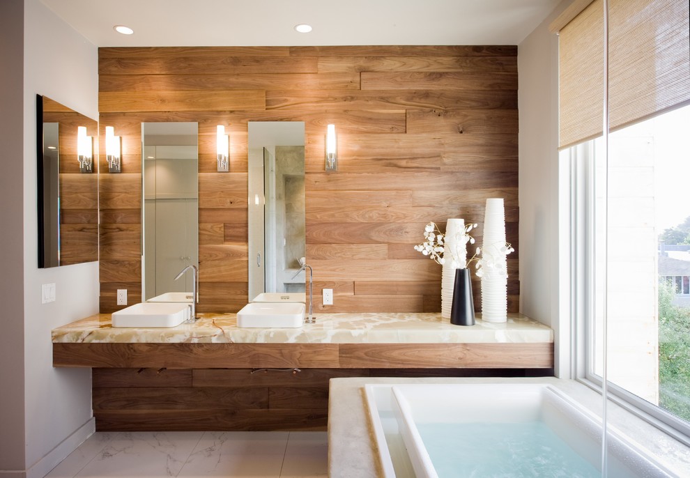 Пример оригинального дизайна: большая главная ванная комната в современном стиле с настольной раковиной, столешницей из оникса, белой плиткой, керамической плиткой, полом из керамической плитки, накладной ванной, коричневыми стенами и бежевой столешницей