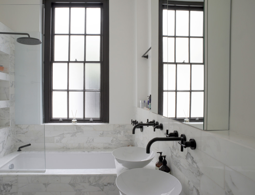 Esempio di una stanza da bagno design con vasca da incasso, vasca/doccia e pavimento in marmo