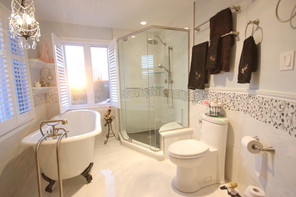 Cette photo montre une salle de bain chic avec une baignoire sur pieds, une douche d'angle, WC à poser, un carrelage blanc et des carreaux de porcelaine.