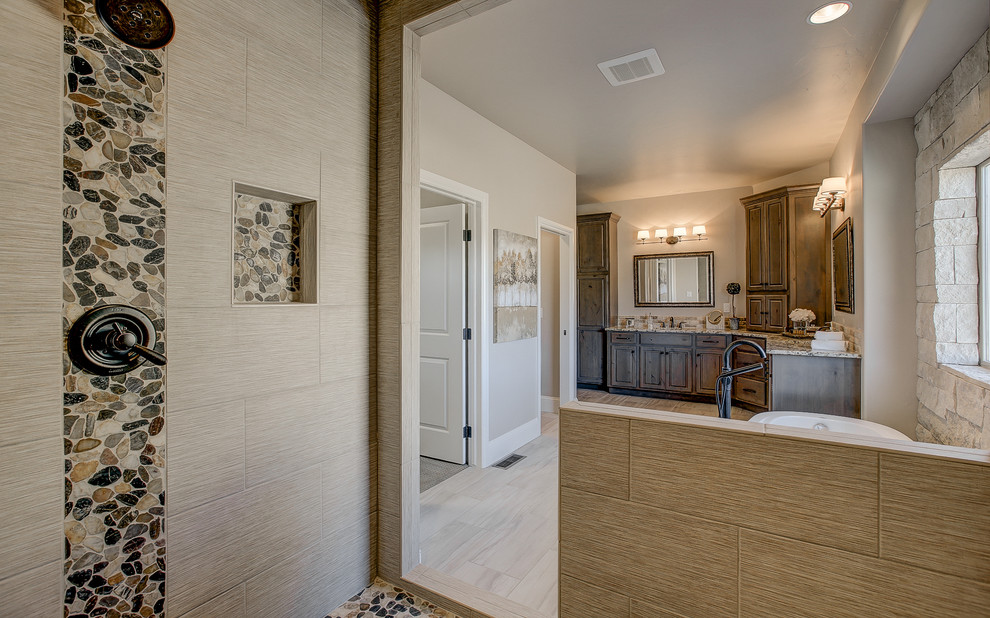 Inspiration for a medium sized classic ensuite bathroom in Denver with raised-panel cabinets, medium wood cabinets, a freestanding bath, an alcove shower, beige tiles, porcelain tiles, beige walls, travertine flooring, a submerged sink and granite worktops.