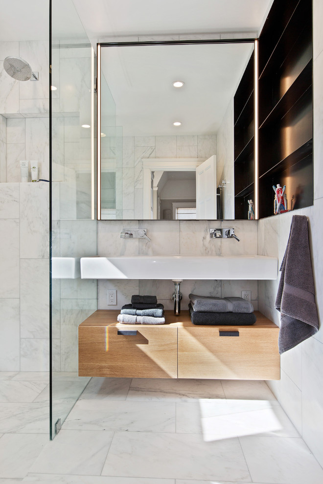 Idée de décoration pour une salle de bain principale design en bois brun de taille moyenne avec un placard à porte plane, une douche ouverte, un carrelage blanc, un carrelage de pierre, un mur blanc, un sol en marbre et un lavabo suspendu.