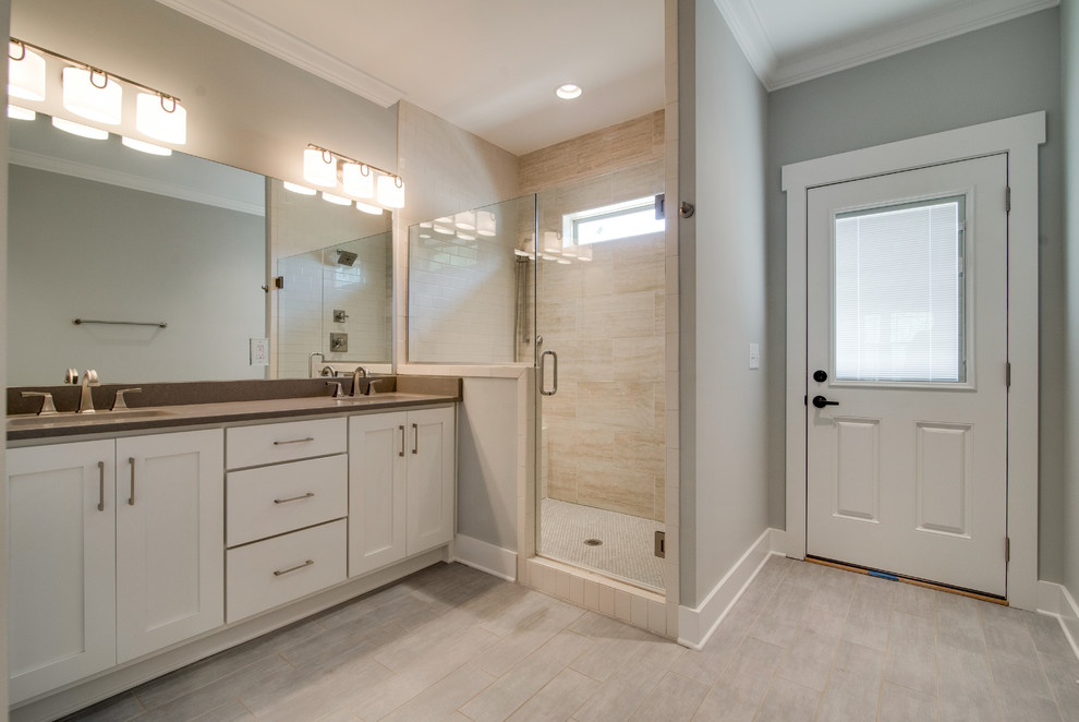 Example of a mid-sized transitional master beige tile and porcelain tile porcelain tile and beige floor alcove shower design in Nashville with shaker cabinets, white cabinets, a two-piece toilet, gray walls, an undermount sink, quartz countertops and a hinged shower door